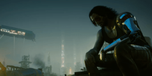 Screenshot des Spiels Cyberpunk 2077: Johnny Silverhand sitzt vor der Skyline der Stadt